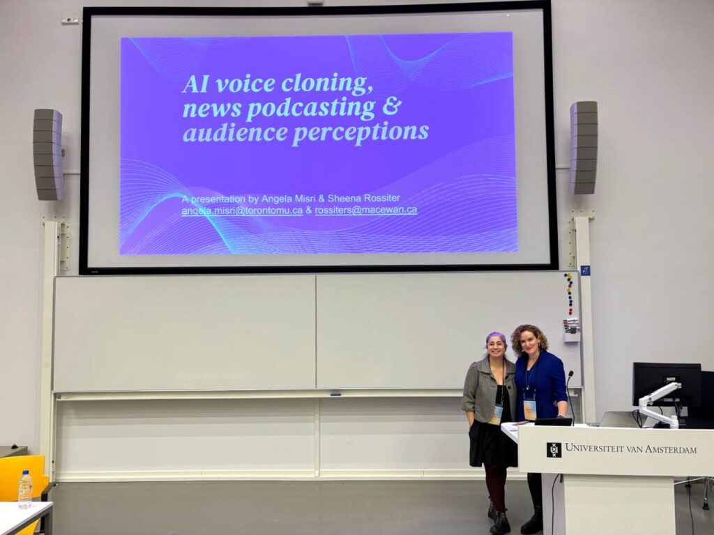 A photo of two professors in front of their projected presentation.